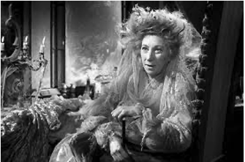 Image of old woman sitting in large ornate chair, dressed in a wedding dress.